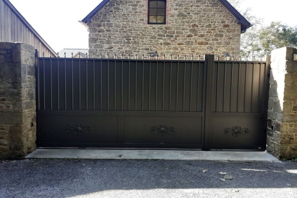 portail de style classique, noir devant maison de pierre à Dinan