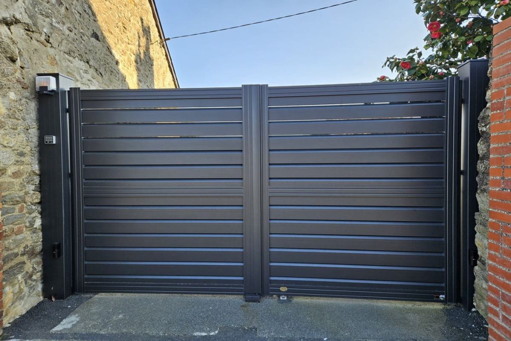 Portail électrique entre un mur et un pilier à Taden